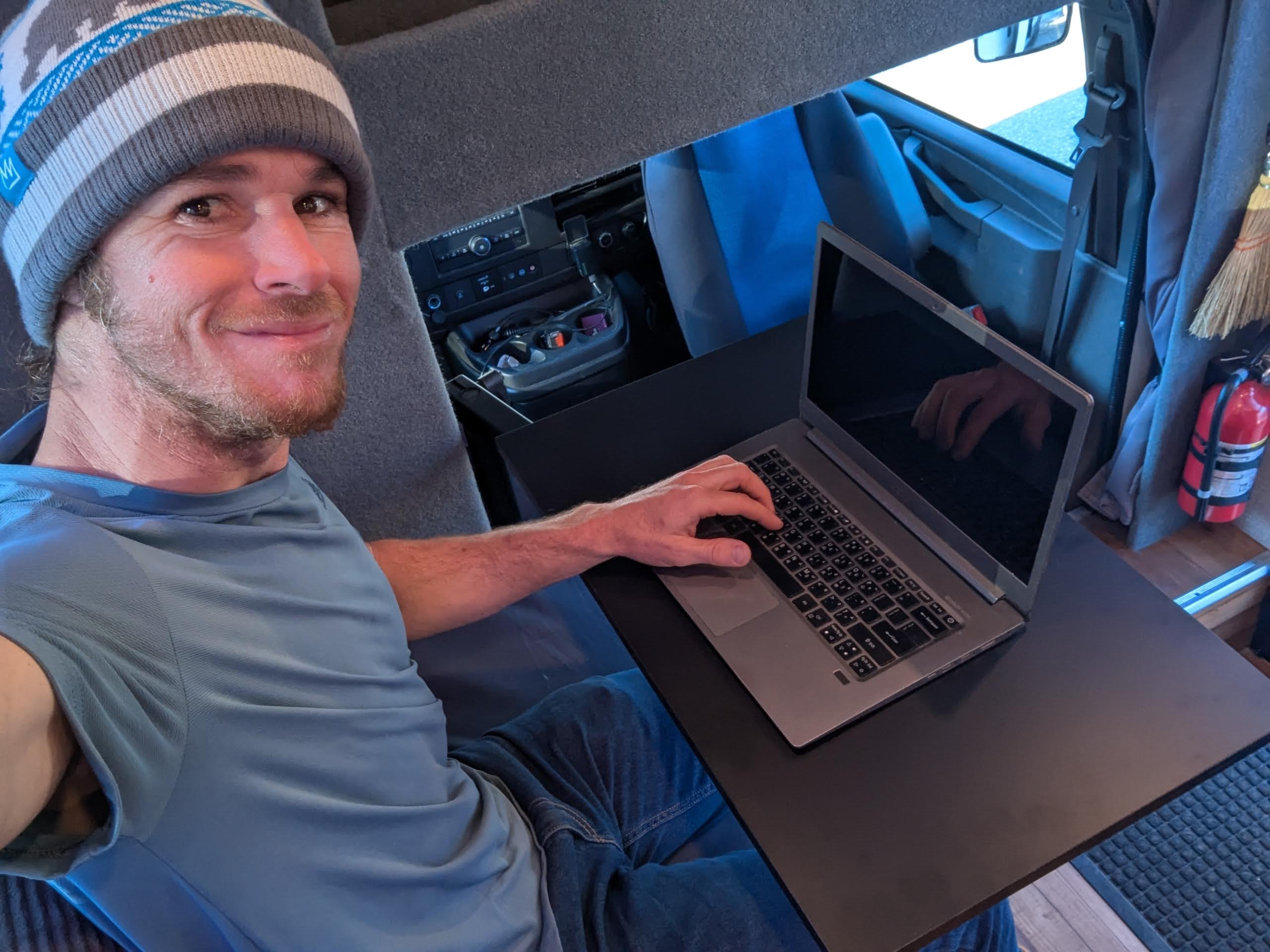 Fold-out desk inside custom ski van — remote work ready with Starlink internet